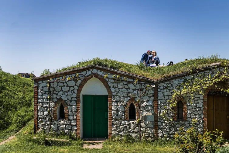 Mladý pár sedící ma vinnem sklepě