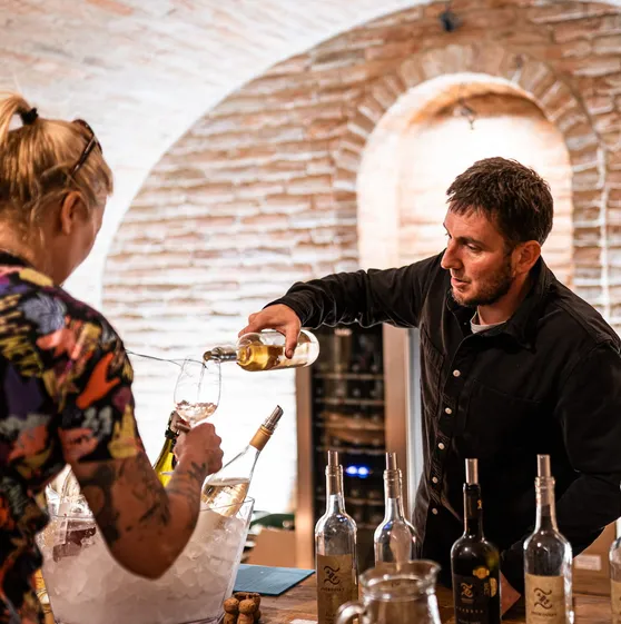 Vinař nalévá víno do sklenice